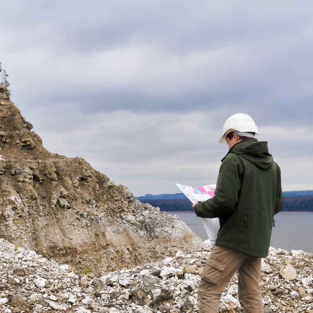 Geologist with a map near the rocky river bank
