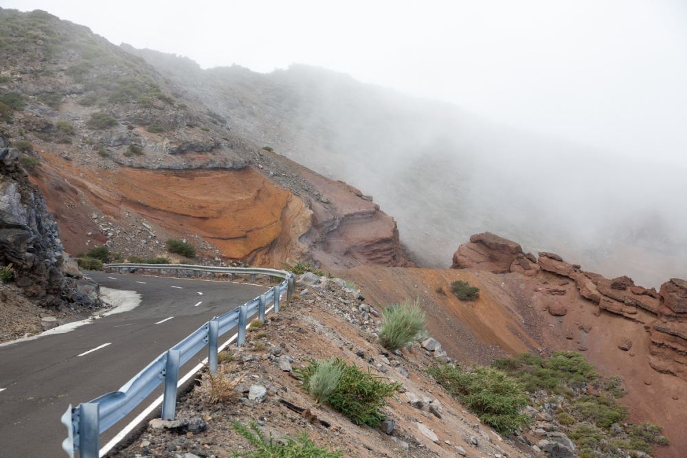 High angle of road to the top of caldera de taburiente volcano on canary islands under foggy clouds
